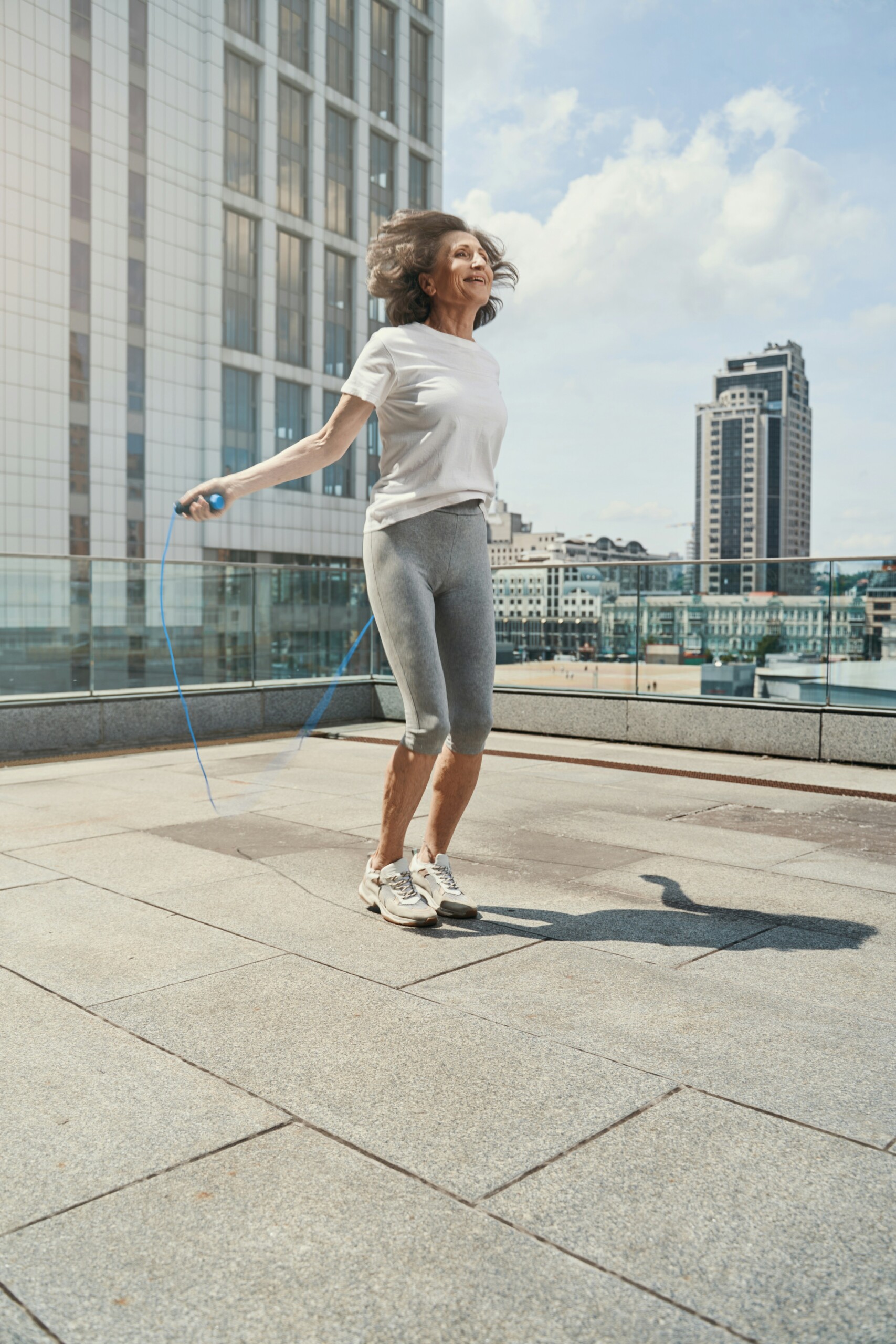 Lady jumping rope around high rise buildings