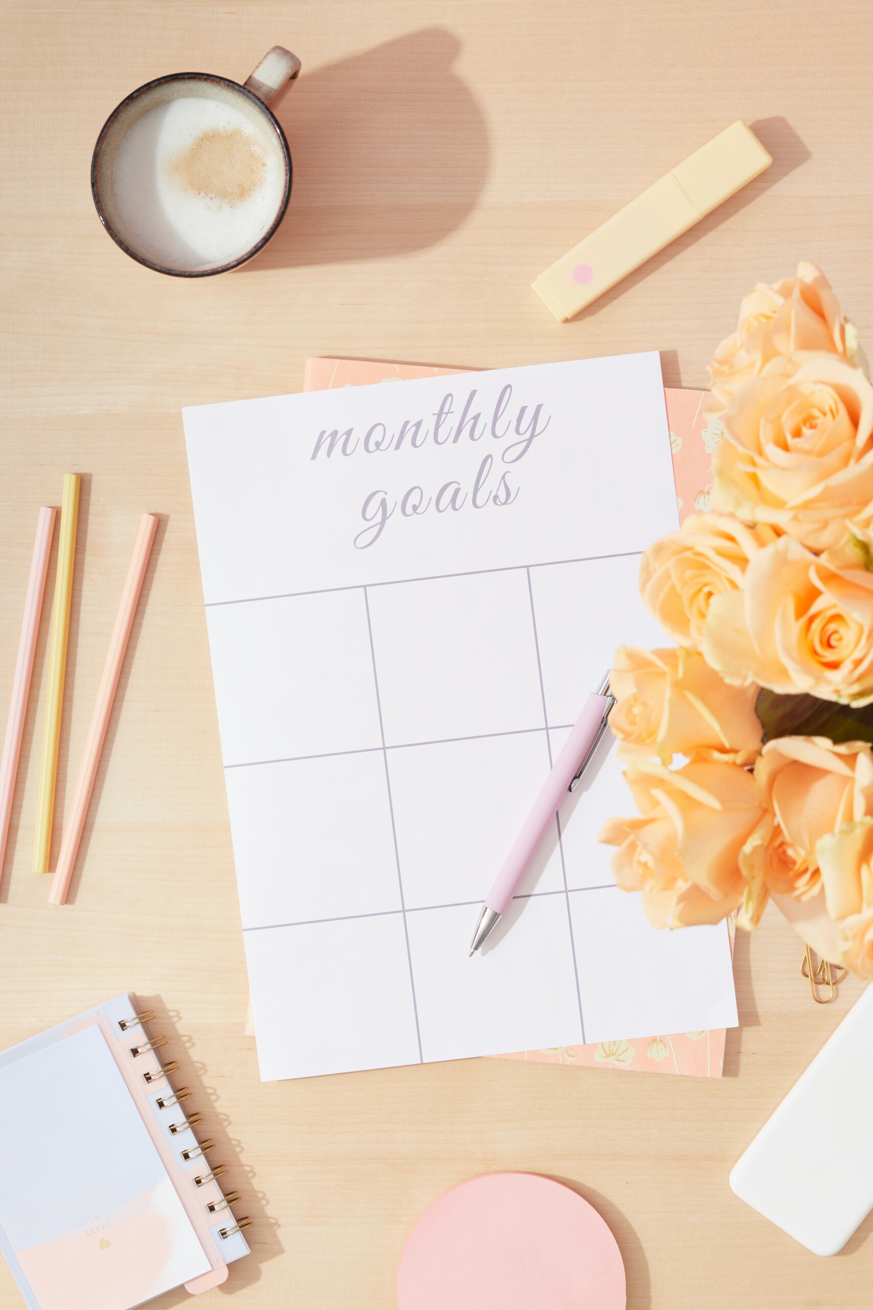 a monthly setting goals planner with pencils, pen and flowers